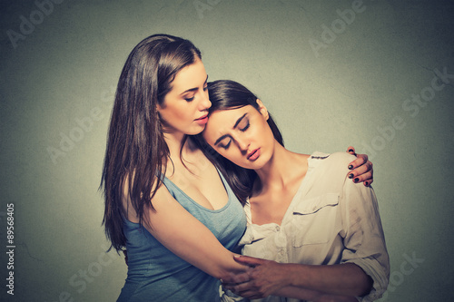 Фотография Sad unhappy young woman being consoled by her friend