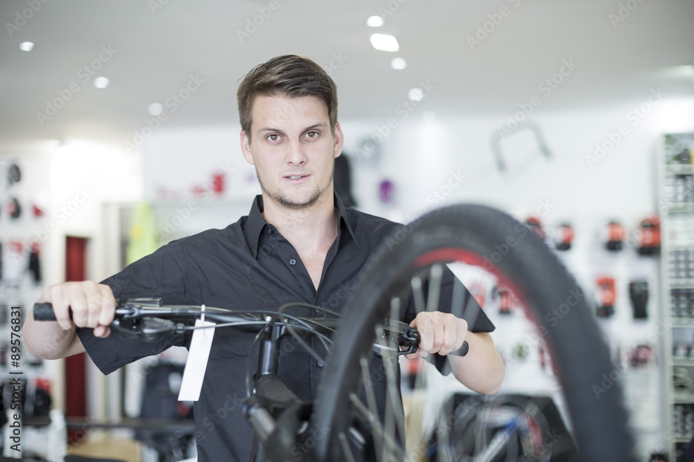 Young man working in bicycle shop Young man working in bicycle shop