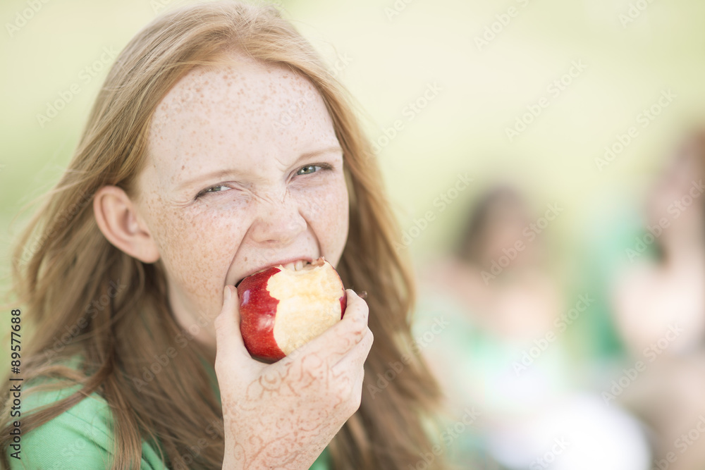 Portrait of girl with red hair eating an apple Portrait of girl with red hair eating an apple