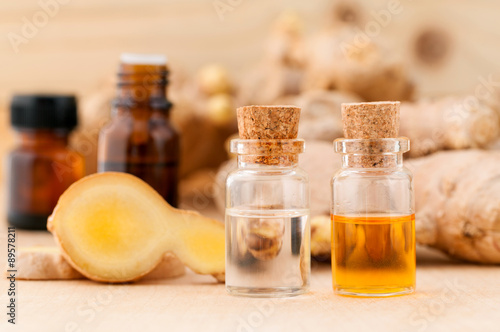Wallpaper Mural Bottles of ginger oil and ginger on wooden background with selec Torontodigital.ca