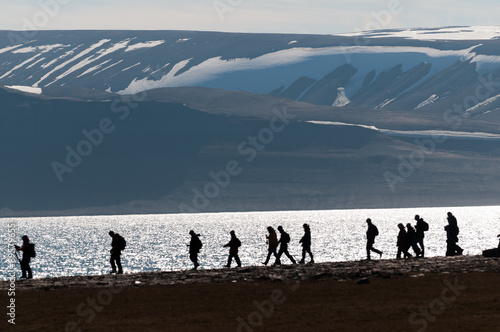 Silhouetted group of hikers in Barentsoya, Svalbard, Norway.