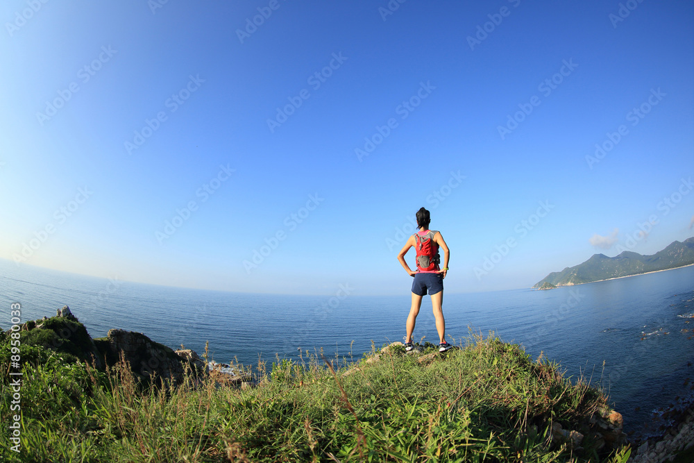 young fitness woman trail runner enjoy the view on seaside mountain