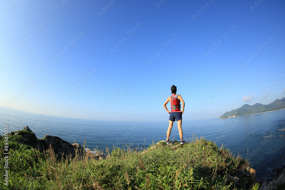 Obraz premium young fitness woman trail runner enjoy the view on seaside mountain