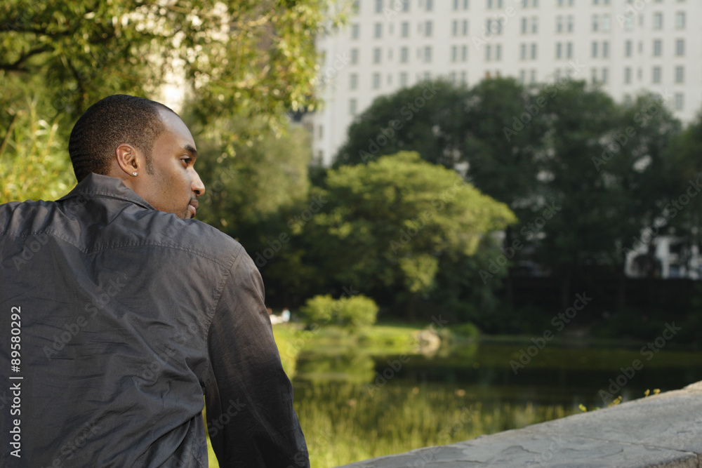 A young man on a park bridge. Shot from behind in profile. A young man on a park bridge. Shot from behind in profile.