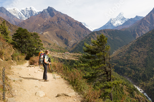 Woman backpacker slooking at Ama Dablam mountain. © subbotsky