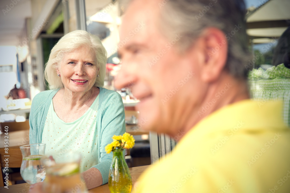 Portrait of happy senior woman sitting with her husband in a cafe Portrait of happy senior woman sitting with her husband in a cafe