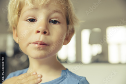 Portrait of little boy having sore throat photo