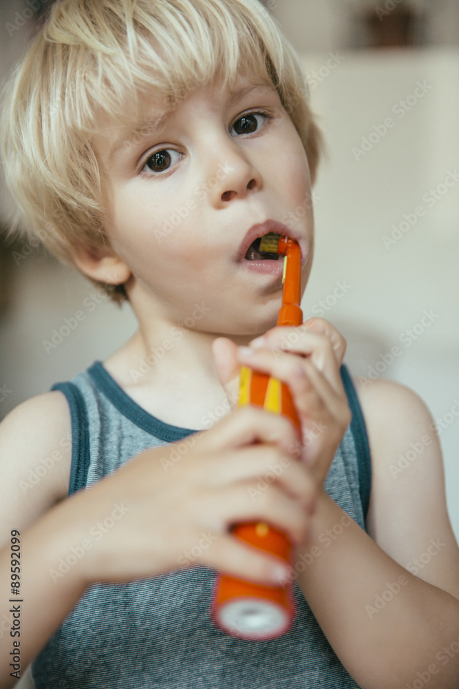 Portrait of little boy brushing his teeth with an electric toothbrush Portrait of little boy brushing his teeth with an electric toothbrush