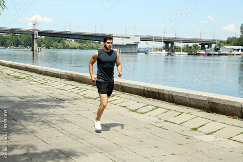 Young man jogging near river © Africa Studio