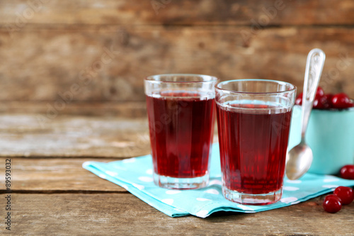 Two glasses with cherry juice on table, on light background