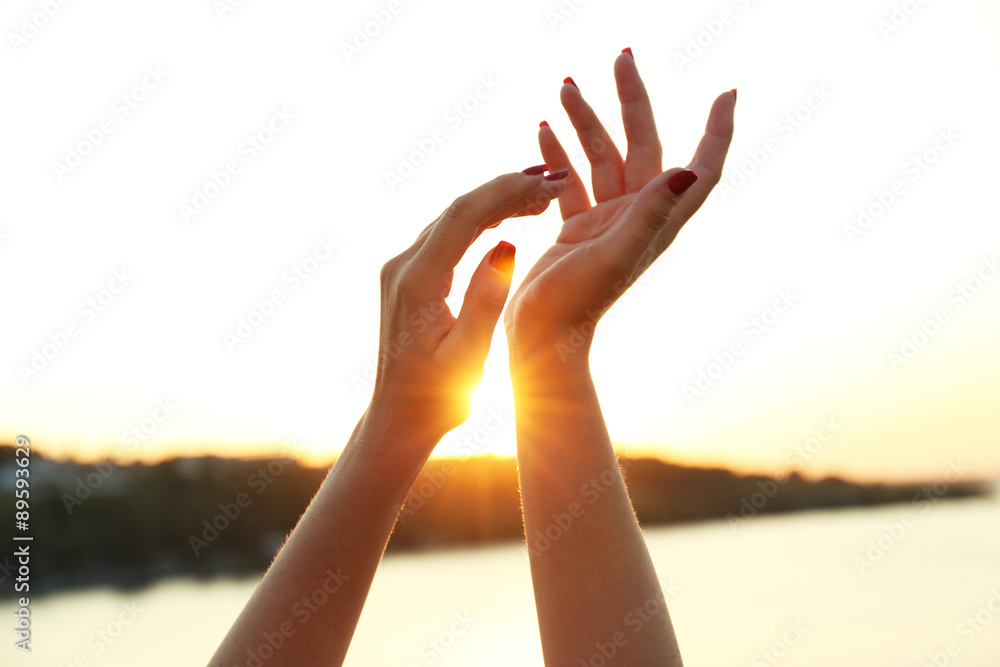 Female hands on sunny sky background Female hands on sunny sky background