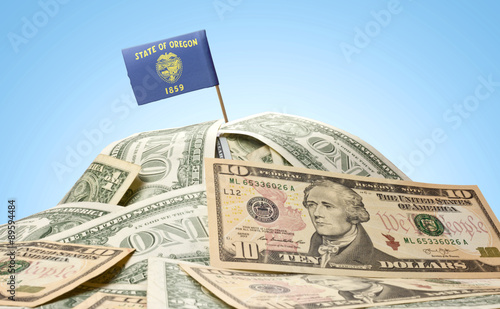 Flag of Oregon sticking in a pile of american dollars.(series)