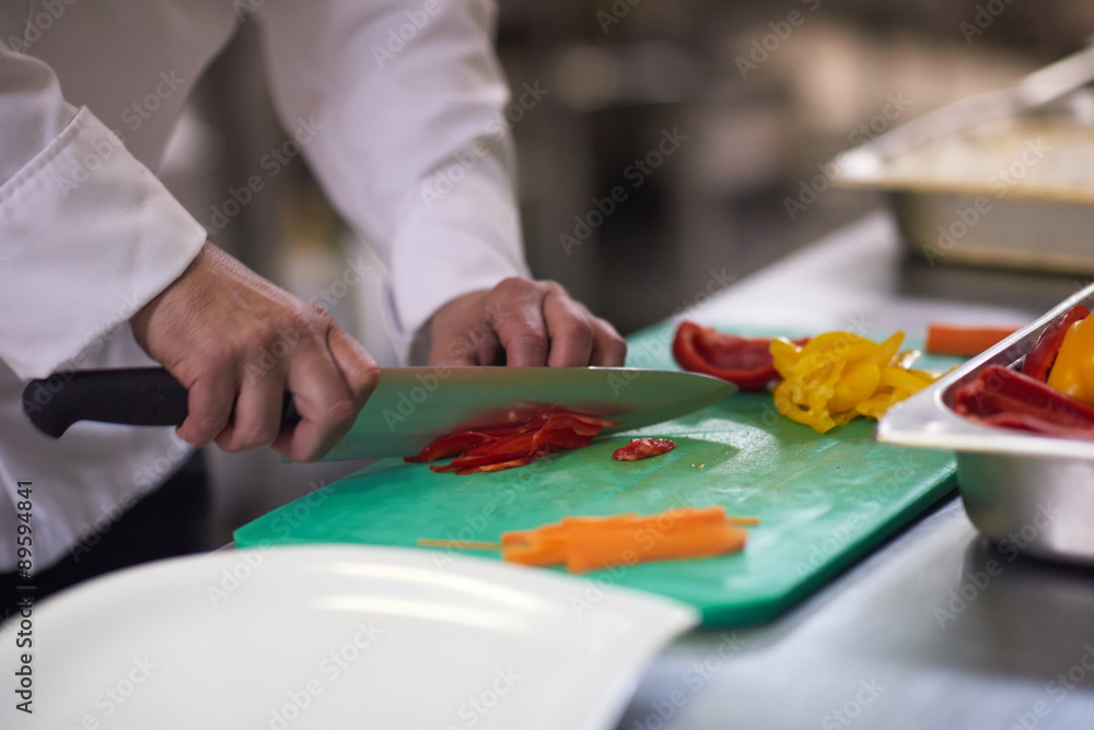 chef in hotel kitchen  slice  vegetables with knife