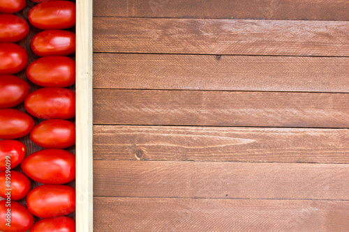 Close-up of fresh, ripe tomatoes on wood background, copy space