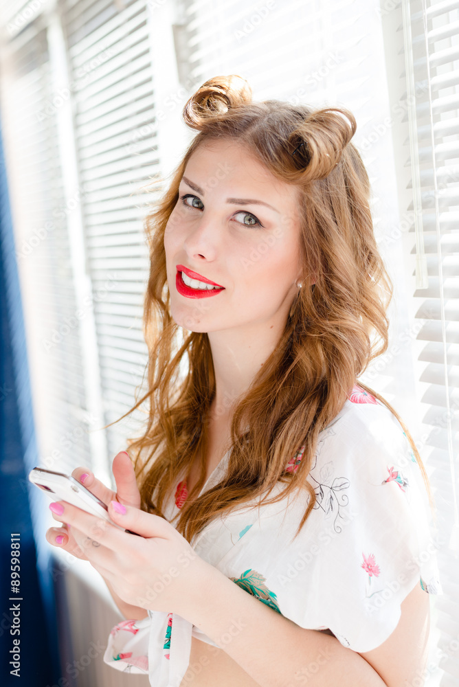 Young pinup lady having fun reading message on mobile phone Young pinup lady having fun reading message on mobile phone