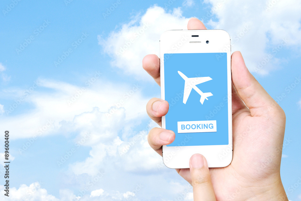 Obraz premium Hand holding mobile phone with airline tickets online booking on