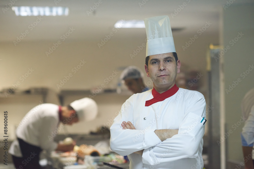 chef in hotel kitchen preparing and decorating food