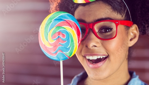 Young woman holding a lollipop against her face 