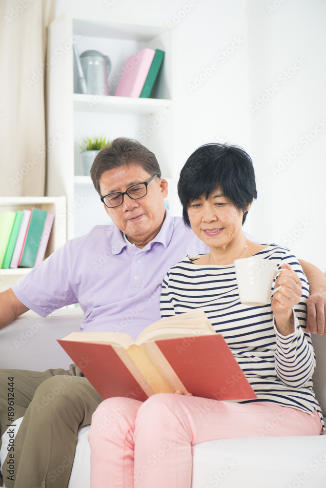 Fototapeta premium senior asian couple reading a book together at home.