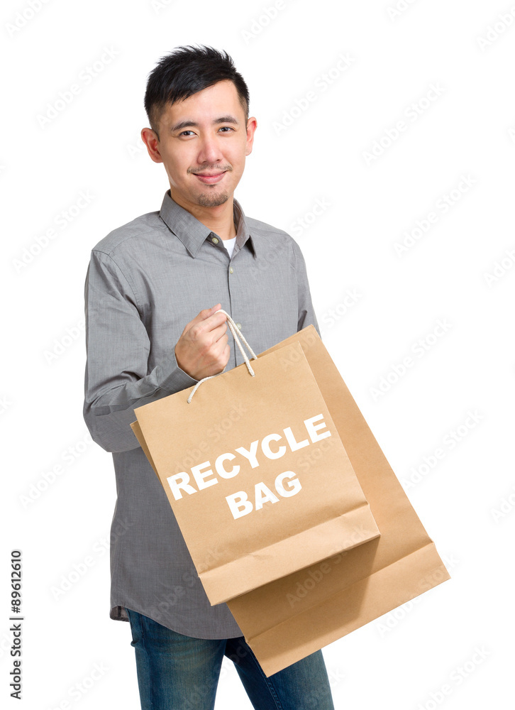 Asian man hold with shopping bag and showing recycle bag Asian man hold with shopping bag and showing recycle bag