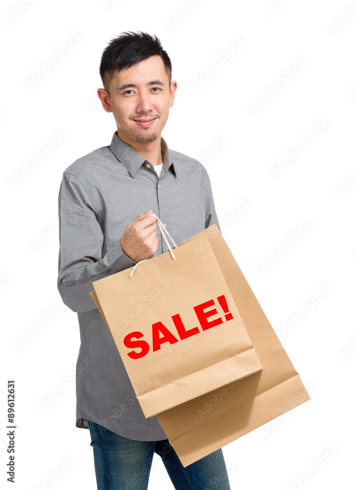 Asian man hold with shopping bag and showing a word sale! Asian man hold with shopping bag and showing a word sale!