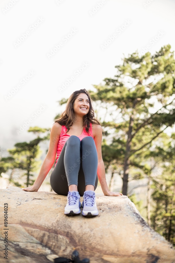 Young happy jogger sitting on rock looking away Young happy jogger sitting on rock looking away