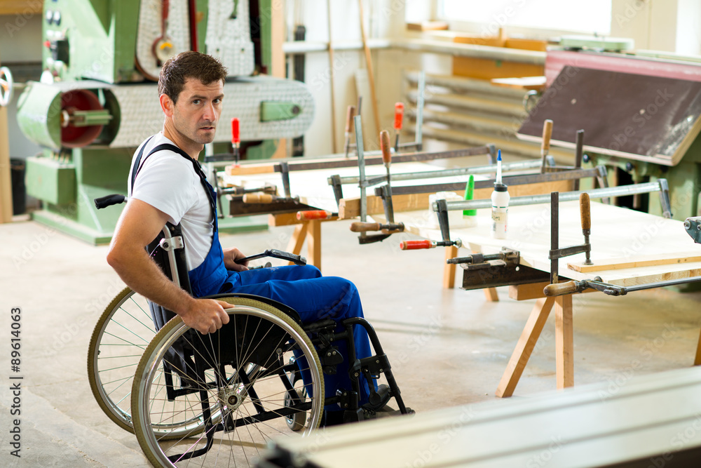 worker in wheelchair in a carpenter's workshop worker in wheelchair in a carpenter's workshop