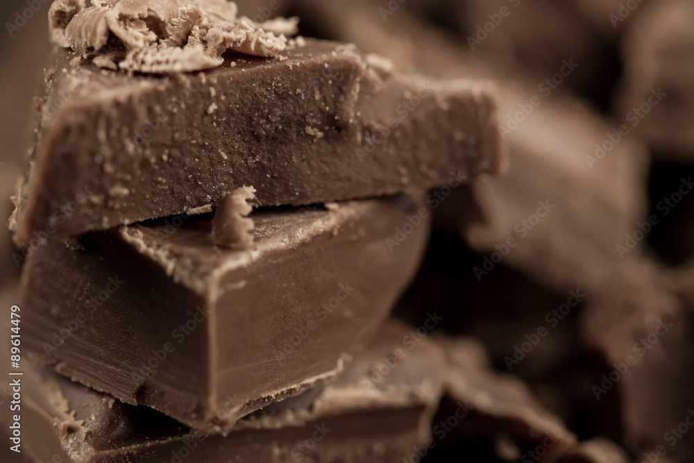 Broken chocolate bar on wooden background, close-up