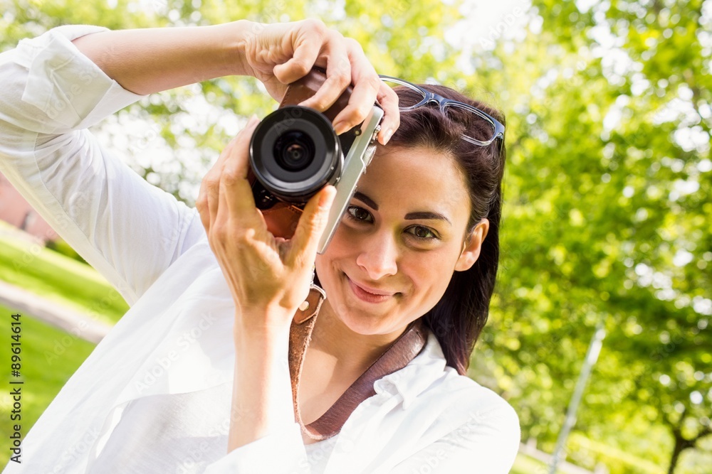 Beautiful brunette taking photo in the park Beautiful brunette taking photo in the park