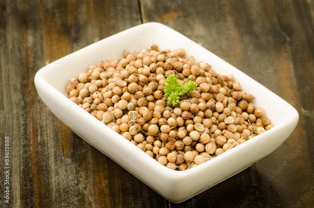Coriander seed in the bowl on wooden background,food ingredient,seasoning Coriander seed in the bowl on wooden background,food ingredient,seasoning