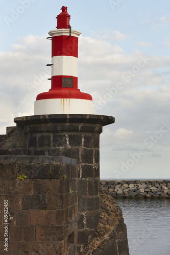 Red and white lighthouse in Povoacao, Sao Miguel, Azores. Portug photo