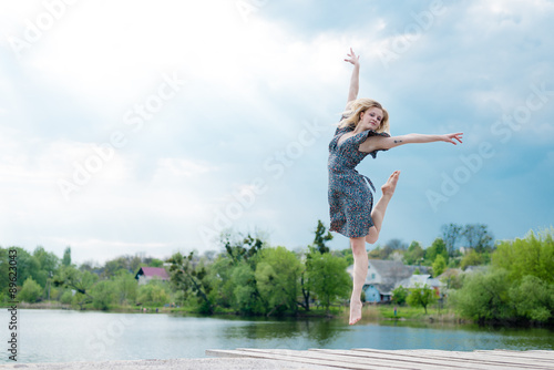 feeling high: beautiful blond young woman dancing by river