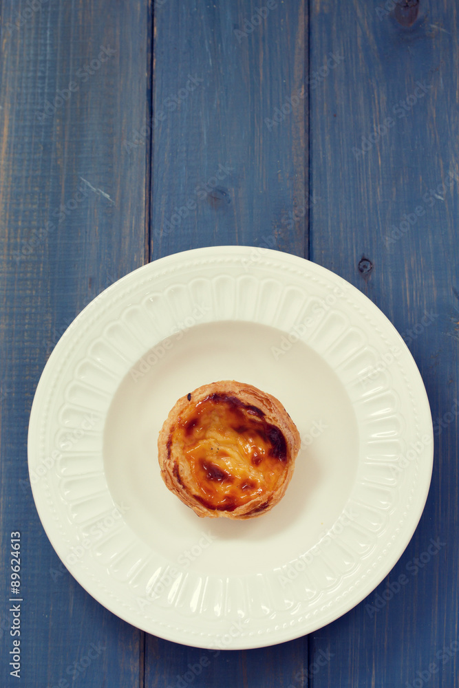 portuguese egg cookie on white dish on blue background portuguese egg cookie on white dish on blue background