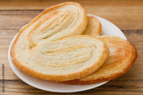 cookies palmier on plate on brown wooden background