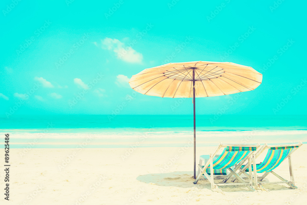 Blue sea and white sand beach with beach chairs and parasol