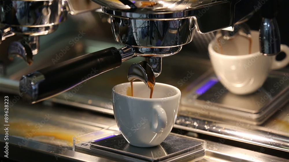 Barista makes coffee in the coffee machine. White coffee mug. Barista makes coffee in the coffee machine. White coffee mug.