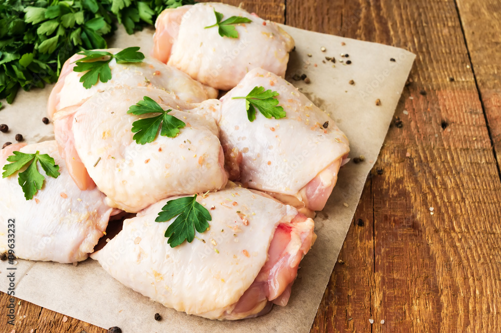 Raw chicken thighs with parsley on wooden table - obrazy, fototapety, plakaty 