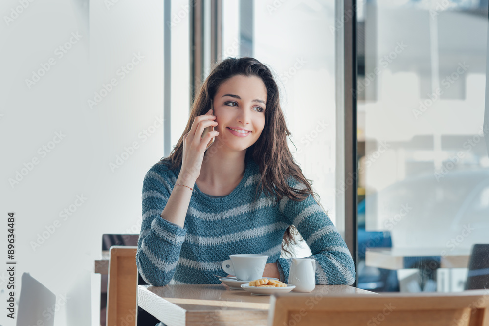 Smiling woman at the bar having a phone call Smiling woman at the bar having a phone call