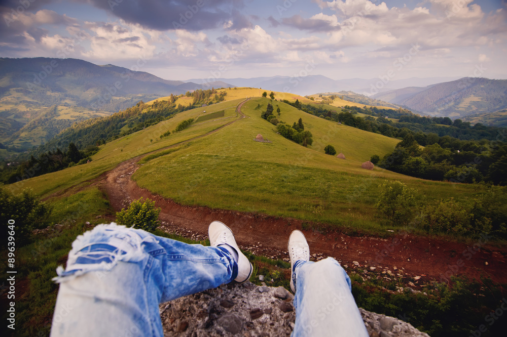 Fototapeta premium Tourist hiker sitting on the rock in mountain