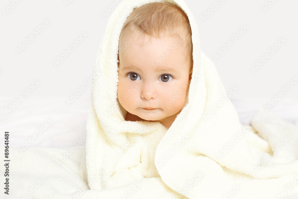 Closeup portrait of cute baby under towel on the bed at home Closeup portrait of cute baby under towel on the bed at home