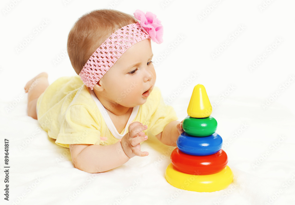 Portrait of cute baby lying and playing with colorful toys Portrait of cute baby lying and playing with colorful toys