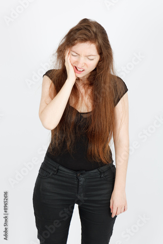 Beautiful businesswoman doing different expressions in different sets of clothes: toothache