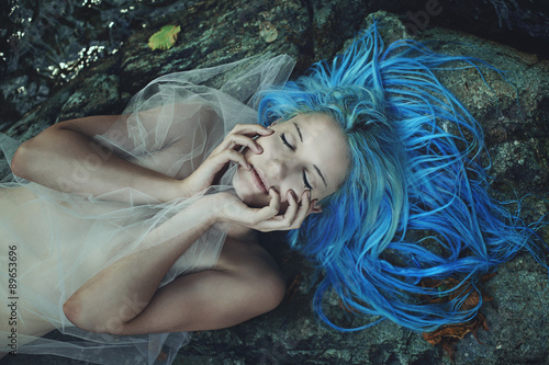Beautiful mermaid sleeping on rocks