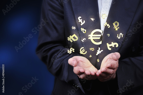 Currency gold symbols in a man hand