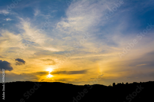silhouette shot image of mountain and sunset sky in background
