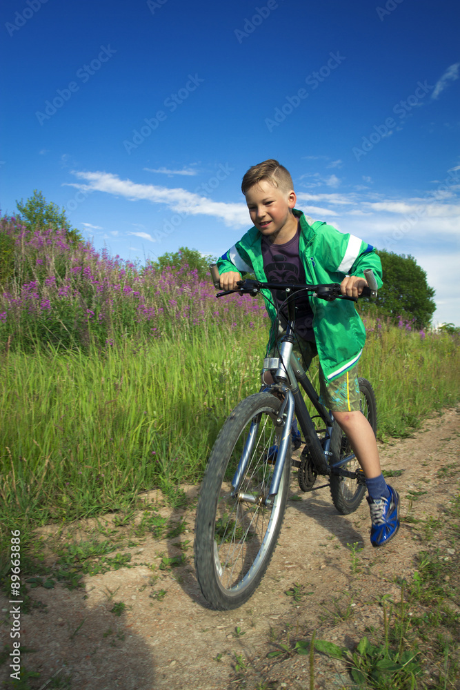 young boy with a bicycle in nature rests.