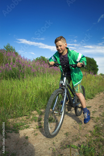 young boy with a bicycle in nature rests.