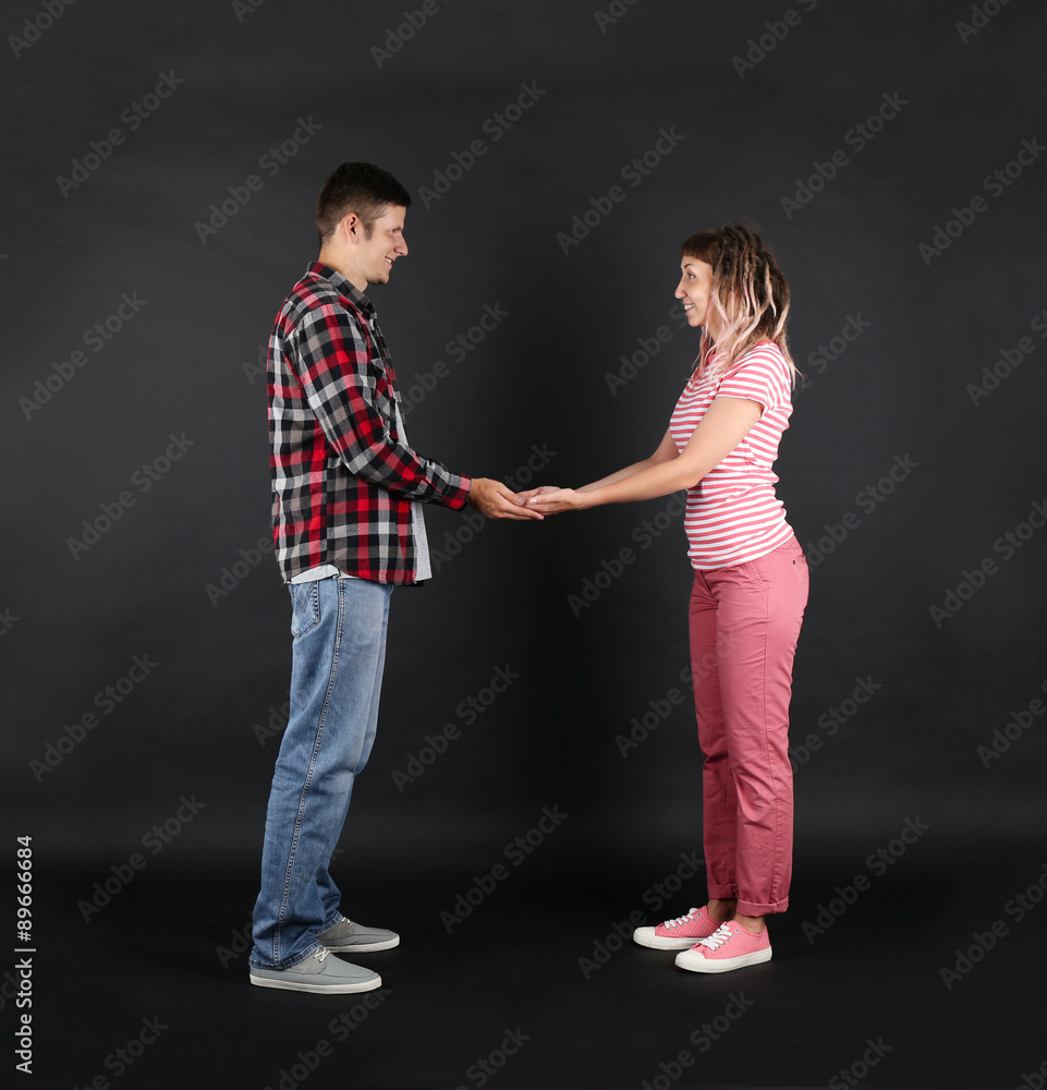 Emotional young couple on black background Emotional young couple on black background