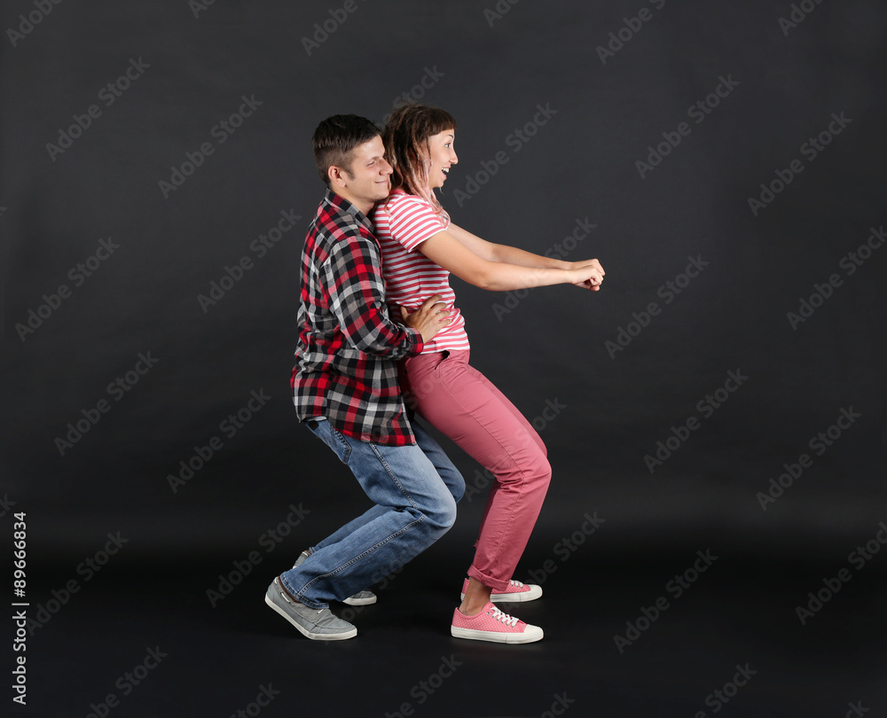 Emotional young couple on black background Emotional young couple on black background