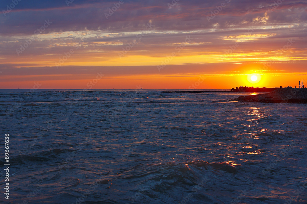 Amazing sea sunset on a stony seashore Amazing sea sunset on a stony seashore